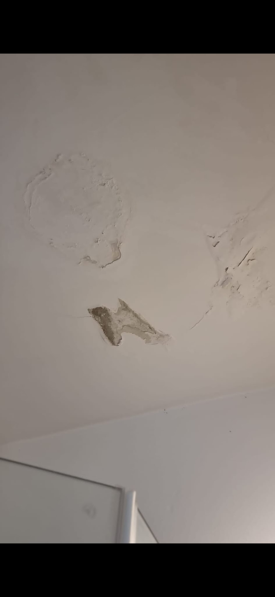 תקרת מקלחת לפני התיקון, טיח מתקלף וחור פתוח סביב נזילה